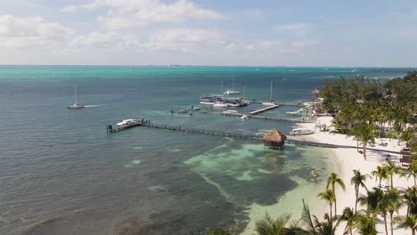 aerial of docks and boats on a tropical island, descending drone shot tropical island mansion