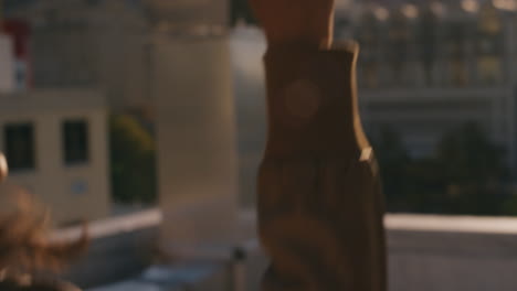 beautiful young caucasian woman blowing bubbles on rooftop at sunset enjoying playful summer day with city in background