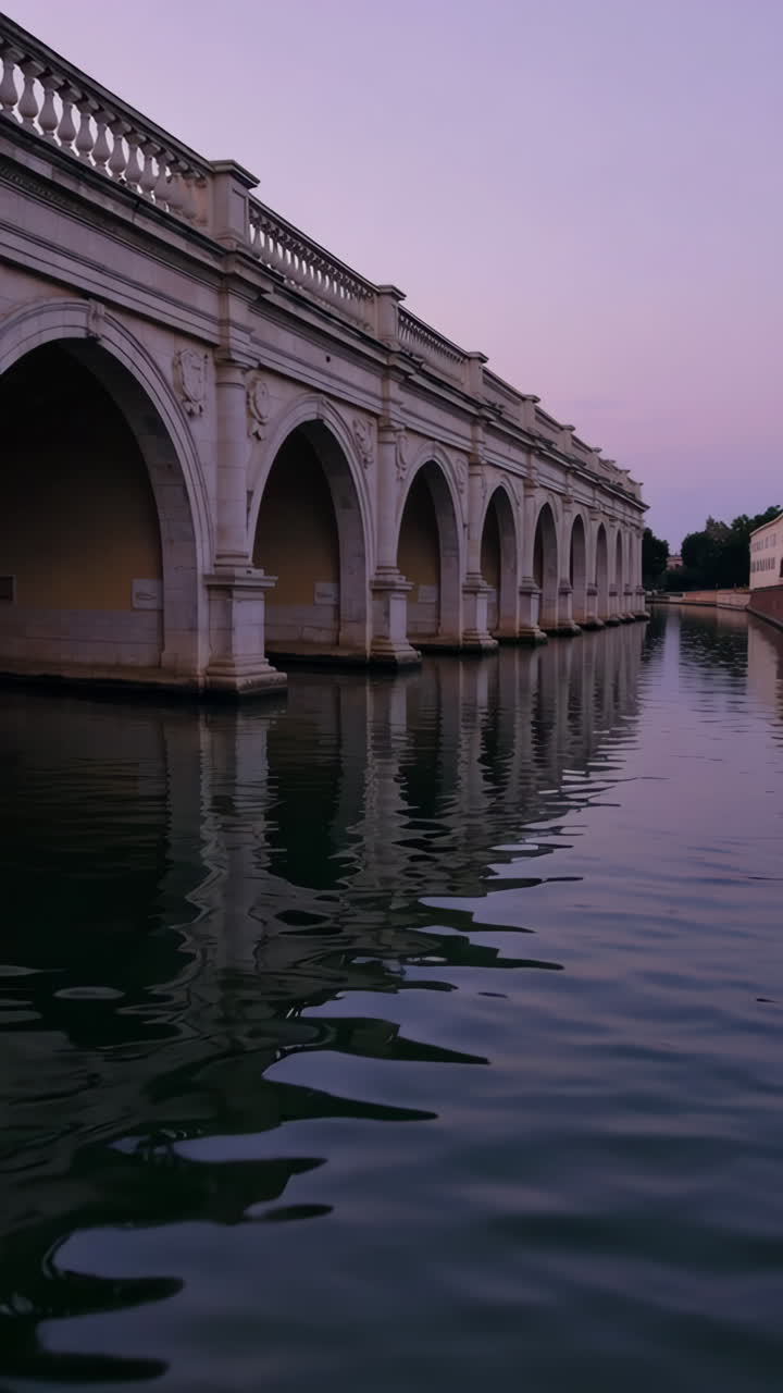 Elegant Stone Bridge over a Calm Canal at Dusk