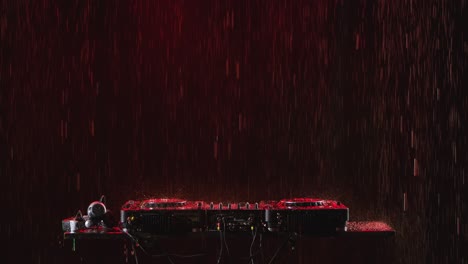 dj equipment in a red rain storm