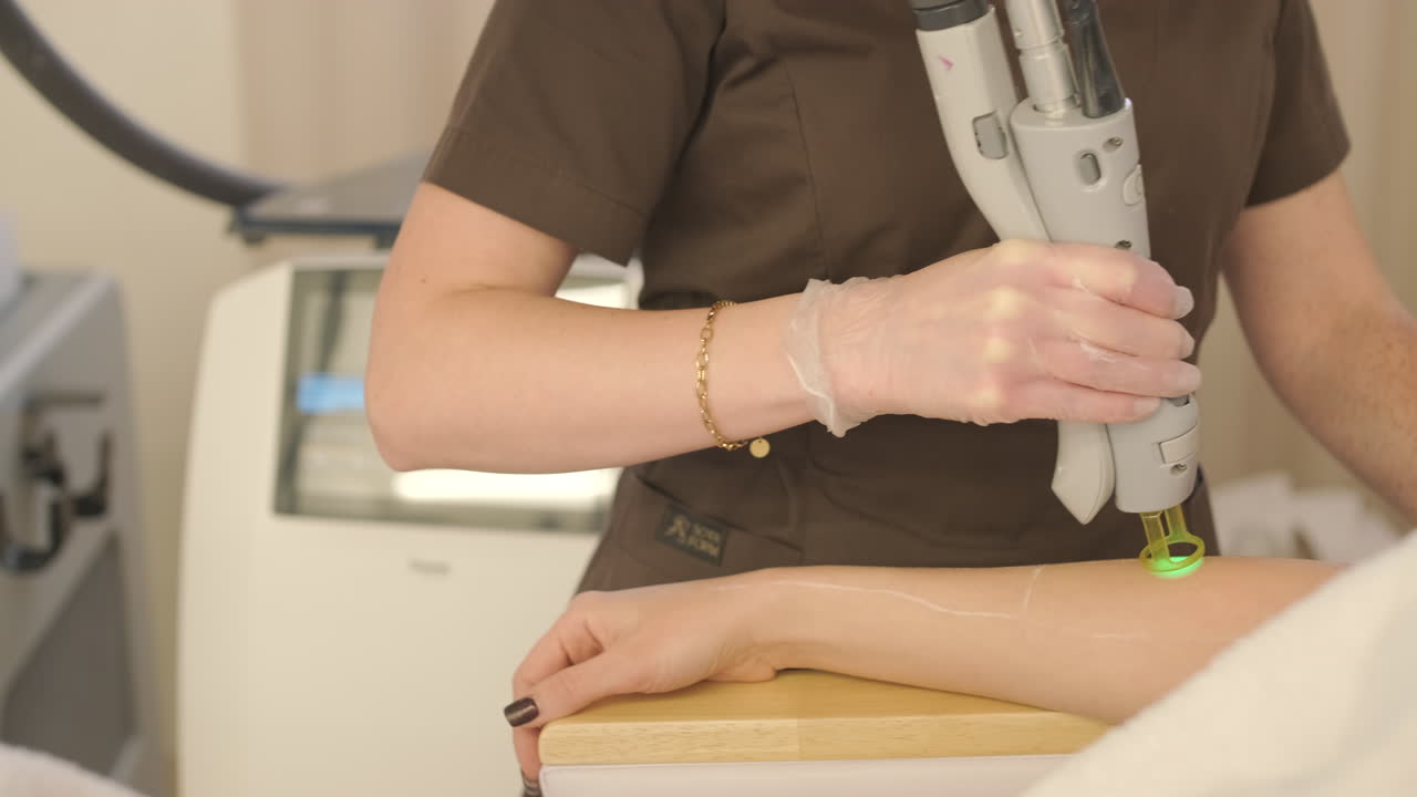 Cosmetologist Performing Laser Hair Removal on Patient's Arm