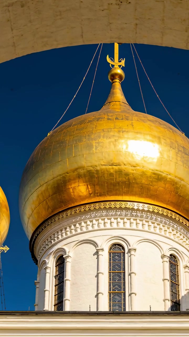 Video verticale: Telecamera che si inclina rivelando una cupola a cipolla dorata in un cortile, con la luce del sole che luccica sull'oro.