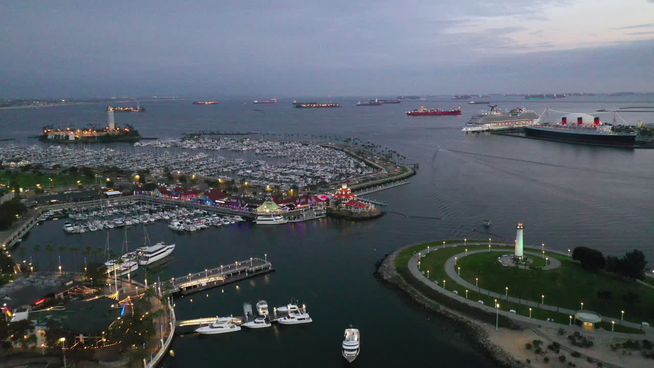 Long Beach Harbour California, USA. Beautiful aerial shot of houses, trees, boats, blue water and the lighthouse. Establishing shot of the area showing the docked RMS Queen Mary
