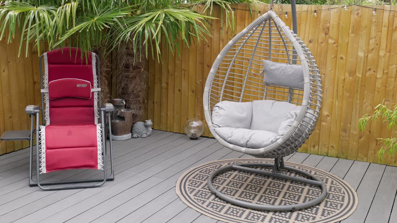 jardín de verano minimalista del reino unido que muestra cubiertas de sillas oscilantes y tumbonas