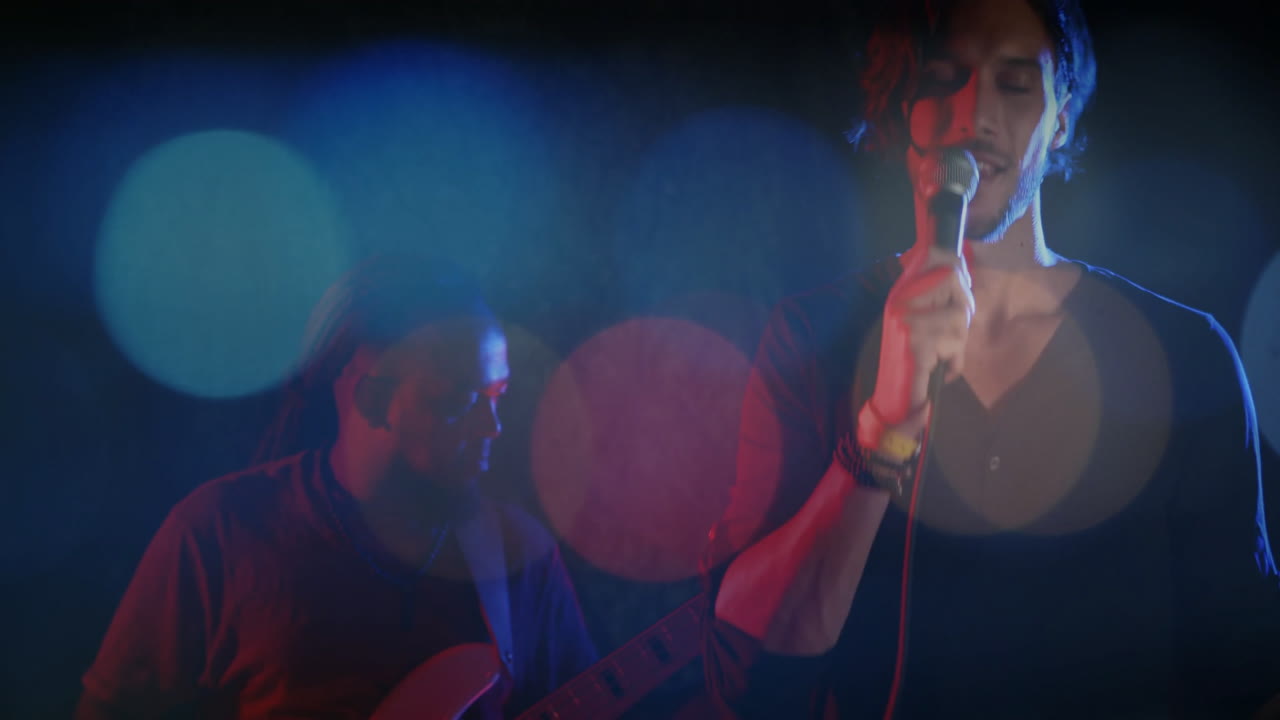 Singer and guitarist performing on concert stage under colored spotlights with animated music notes
