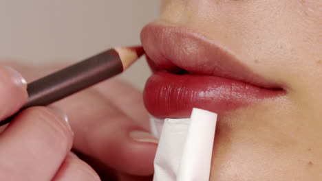 applying red lipstick on beautiful lips