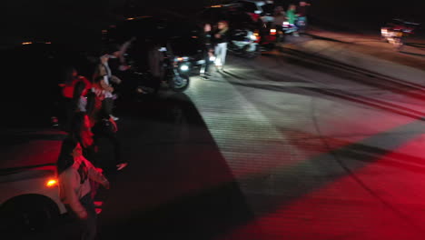 fun time spending at the hip hop party. people dancing near the race cars at night. view from above.