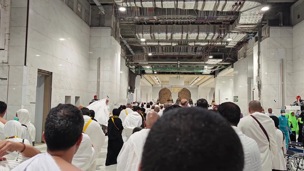 Pellegrini che camminano lungo un corridoio nella Masjid al-Haram