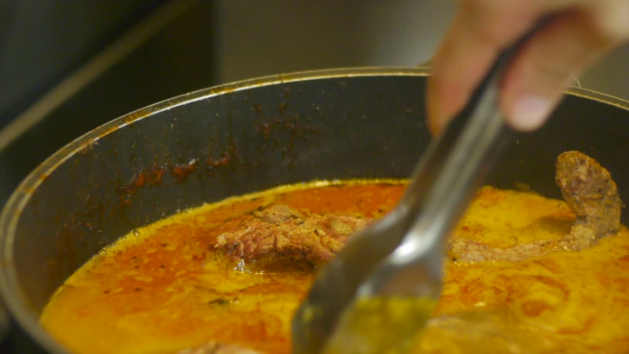 cortes de carne de res colocados en una olla de estofado de sopa para darle más sabor filmados en primer plano