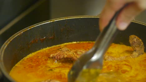 cortes de carne de res colocados en una olla de estofado de sopa para darle más sabor filmados en primer plano