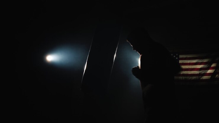 Silhouette di un combattente Trinity in palestra - colpisce un sacco da boxe.