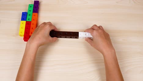 hands assembling and pointing at linking cubes