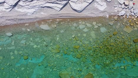 aerial top view over the crystal clear water of the georgian bay, with a rocky coastline, ontario, canada