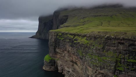 Vuelo-Aéreo-A-Lo-Largo-De-Majestuosos-Acantilados-En-Nubes-De-Tormenta,-Islas-Feroe