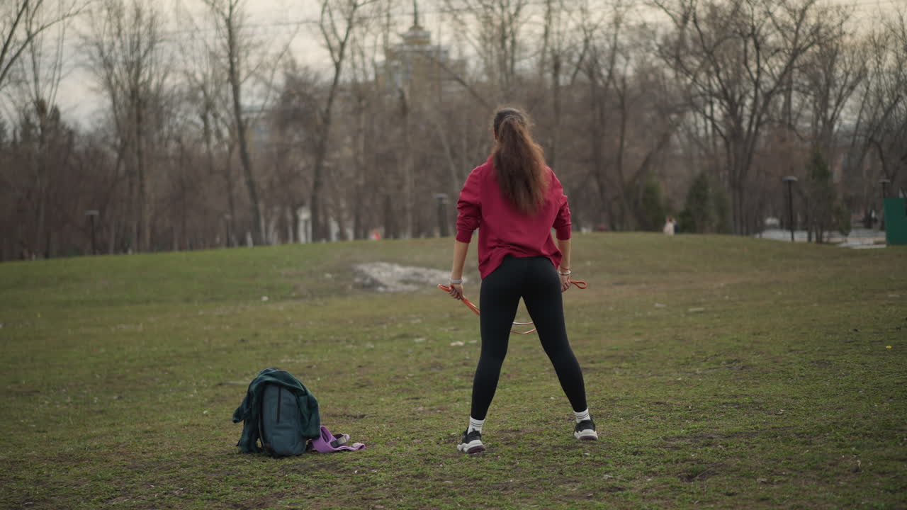 Trainer Demonstrates Stretch, Fitness Instructor In Park Illustrates Band Exercise Posture, Outdoor Training Session Featuring Coach Demonstrating Shoulder Mobility Exercise With Resistance Band