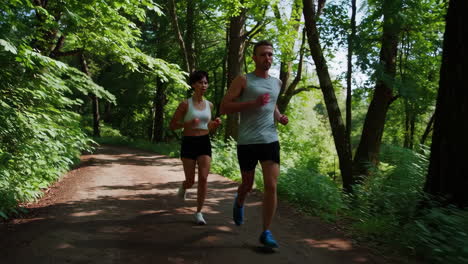 couple running in a forest trail