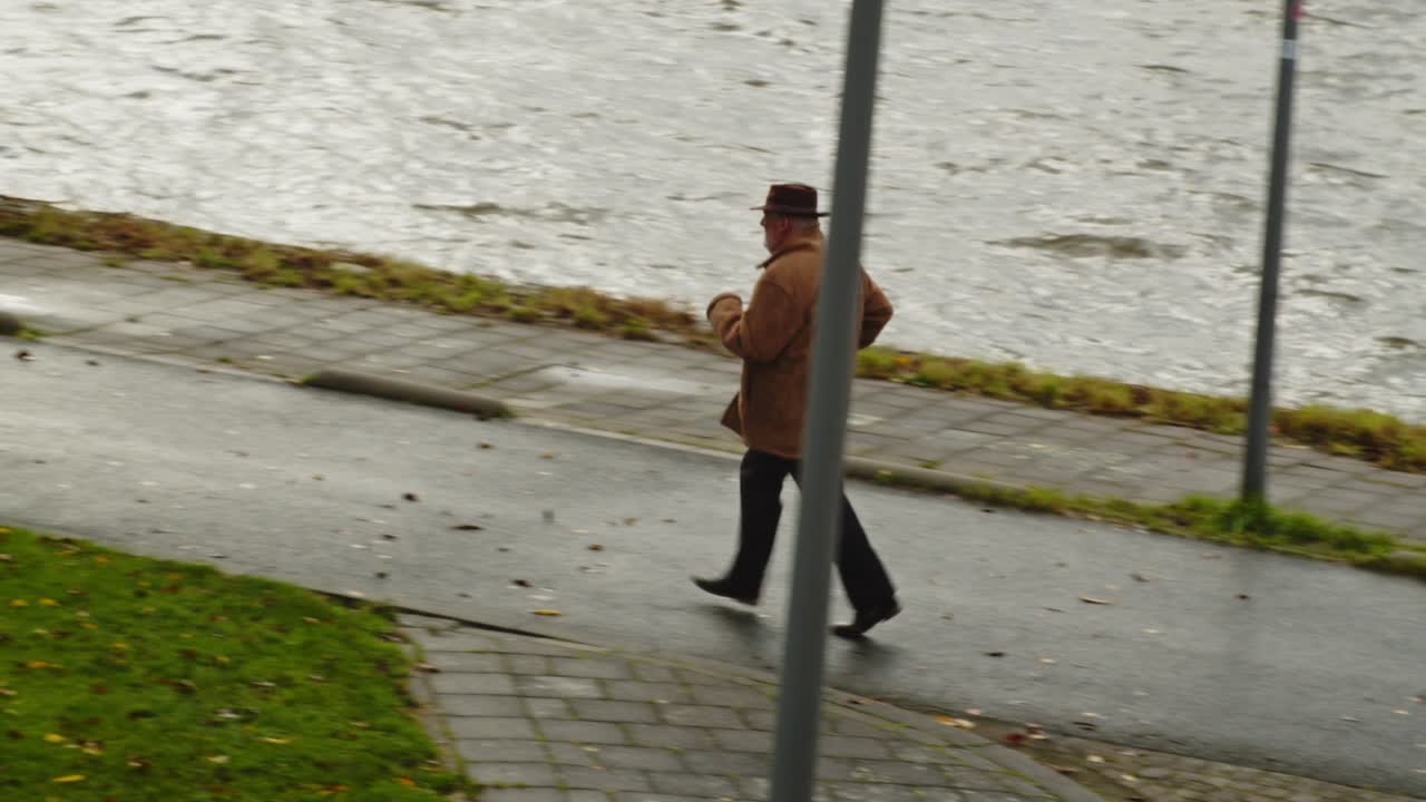 viejo detective privado corriendo por el camino junto al río