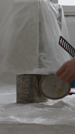 man opening a can of paint