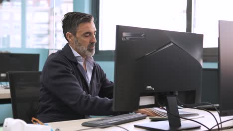 businessman using computer at desk in creative workspace