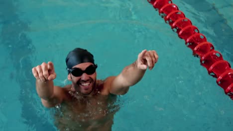 Fit-man-raising-arms-in-the-pool