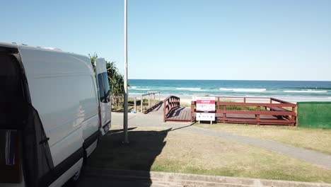 Drone-aerial-shot-of-converted-campervan-by-the-beach-on-summer-day