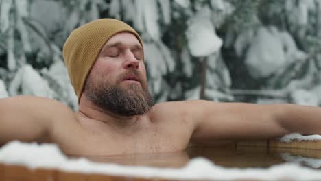 caucasian man during the winter bath in tube outdoors