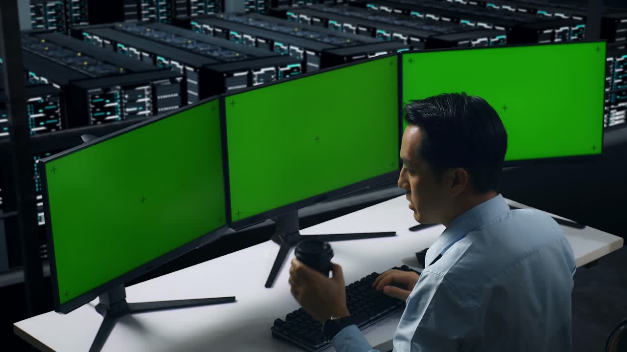 vista trasera de un hombre asiático cansado bostezando mientras trabajaba con un simulacro de varios monitores de computadora en el centro de datos