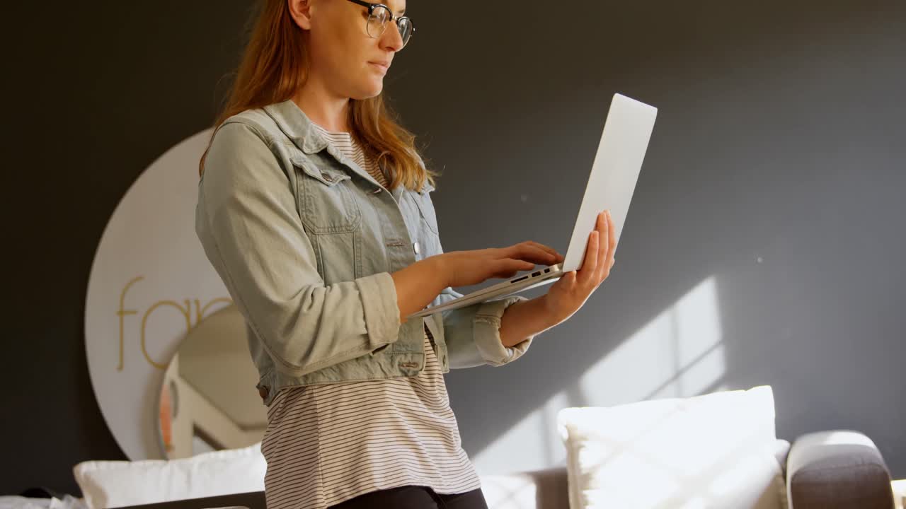 diseñadora de joyas usando una computadora portátil en el taller 4k
