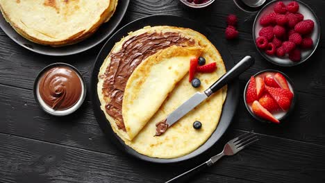 delicious chocolate homemade pancakes on black ceramic plate