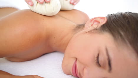 woman enjoying a herbal compress massage