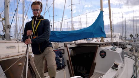 Slow-motion-shot-of-a-captain-walking-along-his-boats-deck-and-looking-at-other-boats