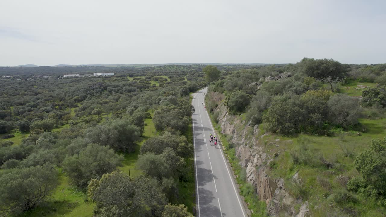 Cyclists ride a winding road between rocky hills in Portalegre Portugal