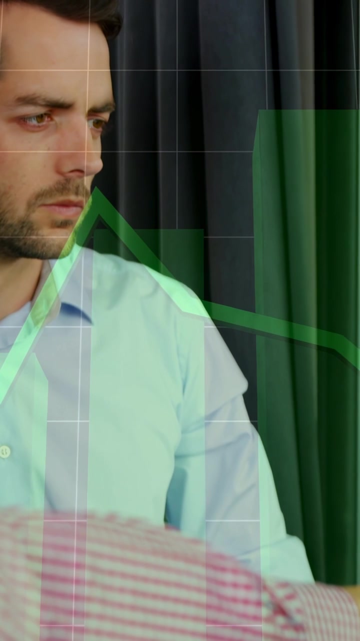 Vídeo vertical: Homem sentado observando um colega gesticulando e estudando um gráfico verde sobreposto para negócios