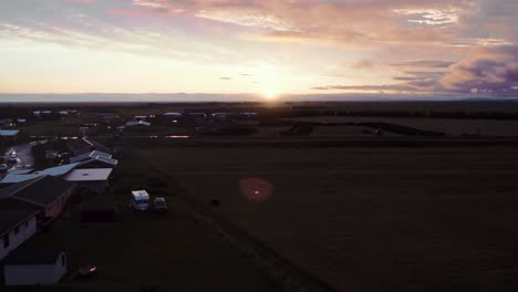 Fields-of-beautiful-town-hvolsvöllur,-Iceland-aerial-during-golden-sunset-evening