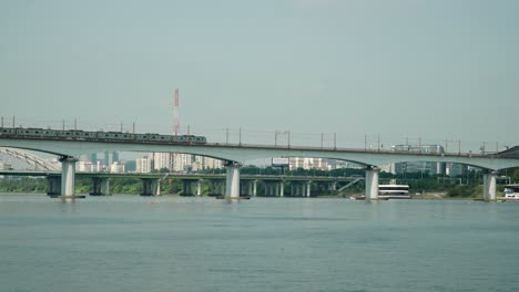 railway train moving along dangsan railroad bridge or iron bridge over han river in yeouido, seoul static daytime