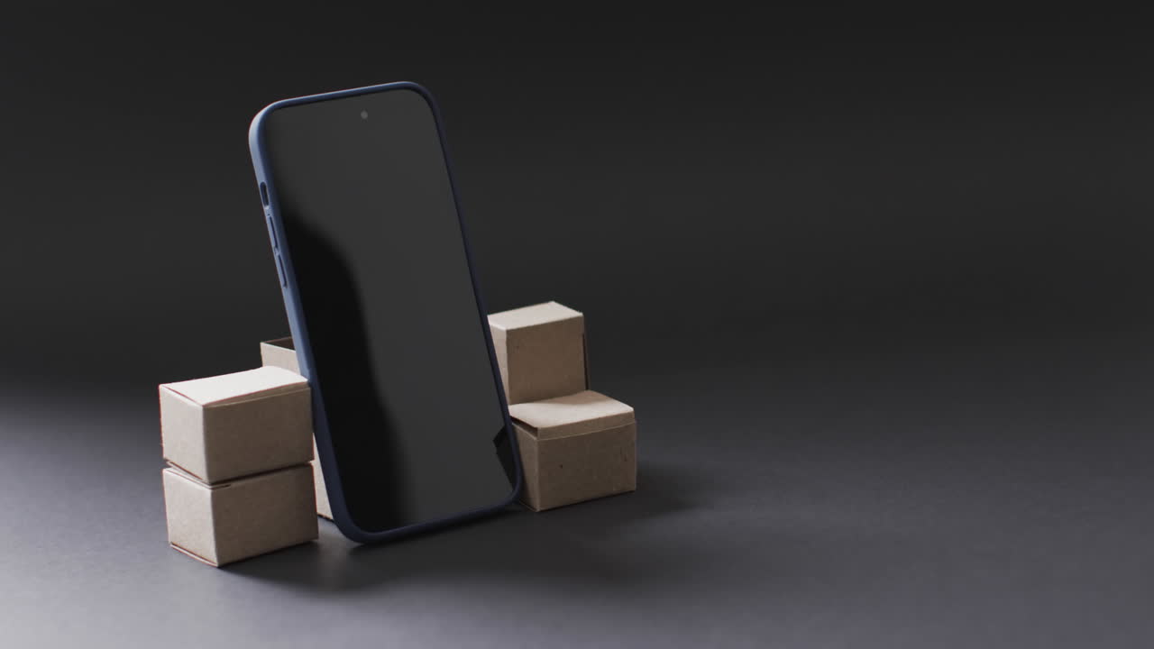 видео смартфона с пустым экраном и коробками с копировальным пространством на черном фоне