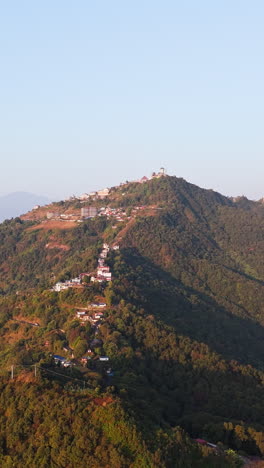 vertical drone shot circling the sarangkot mountain, sunrise in pokhara, nepal