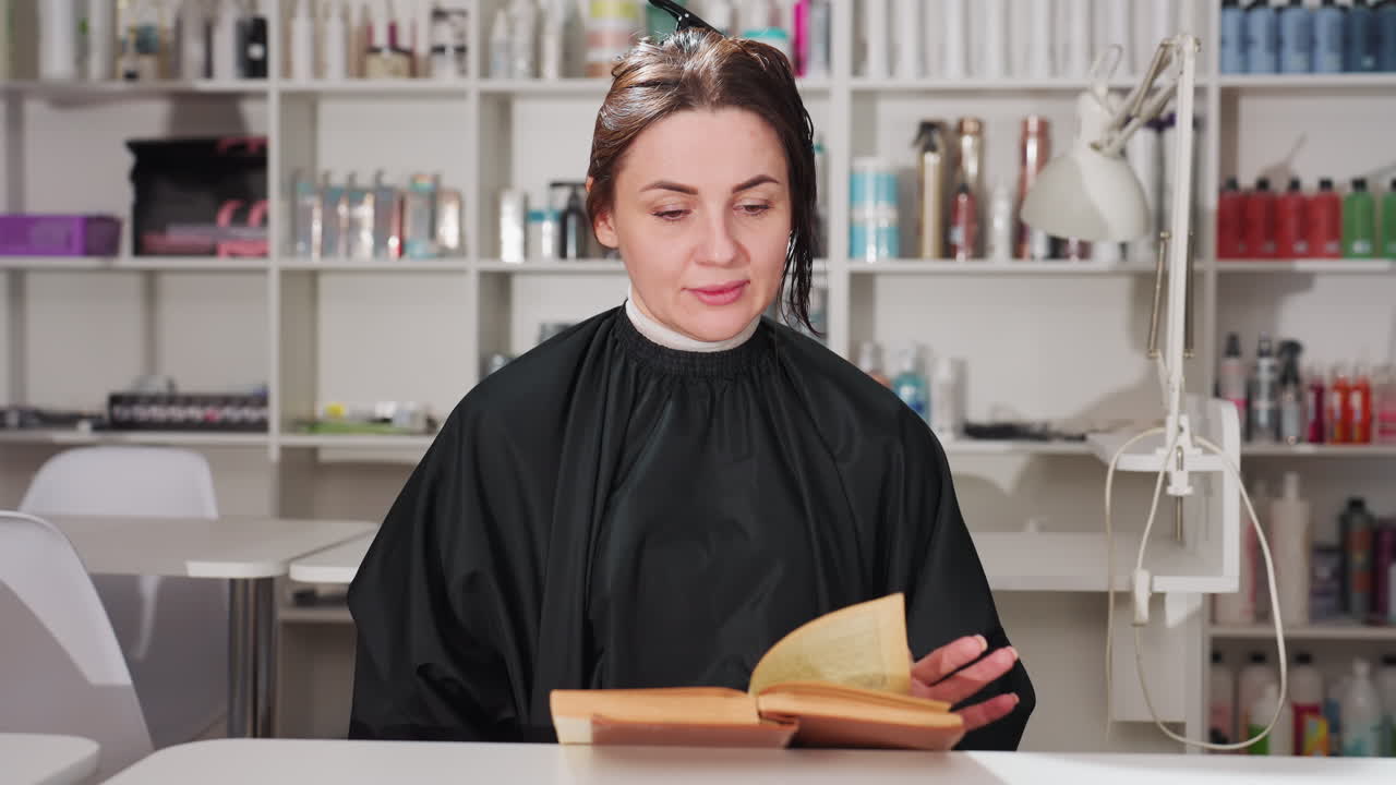 salão tranquilo com cliente atencioso, cena relaxante de estúdio de cabelo com cliente absorto na leitura, atmosfera de salão de beleza tranquila onde o cliente desfruta de um livro em meio a arranjos organizados