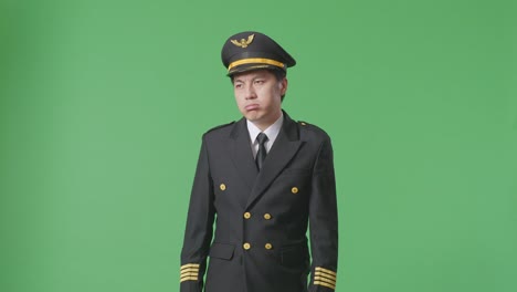 asian man pilot wiping the sweat and being tired while standing in the green screen background studio