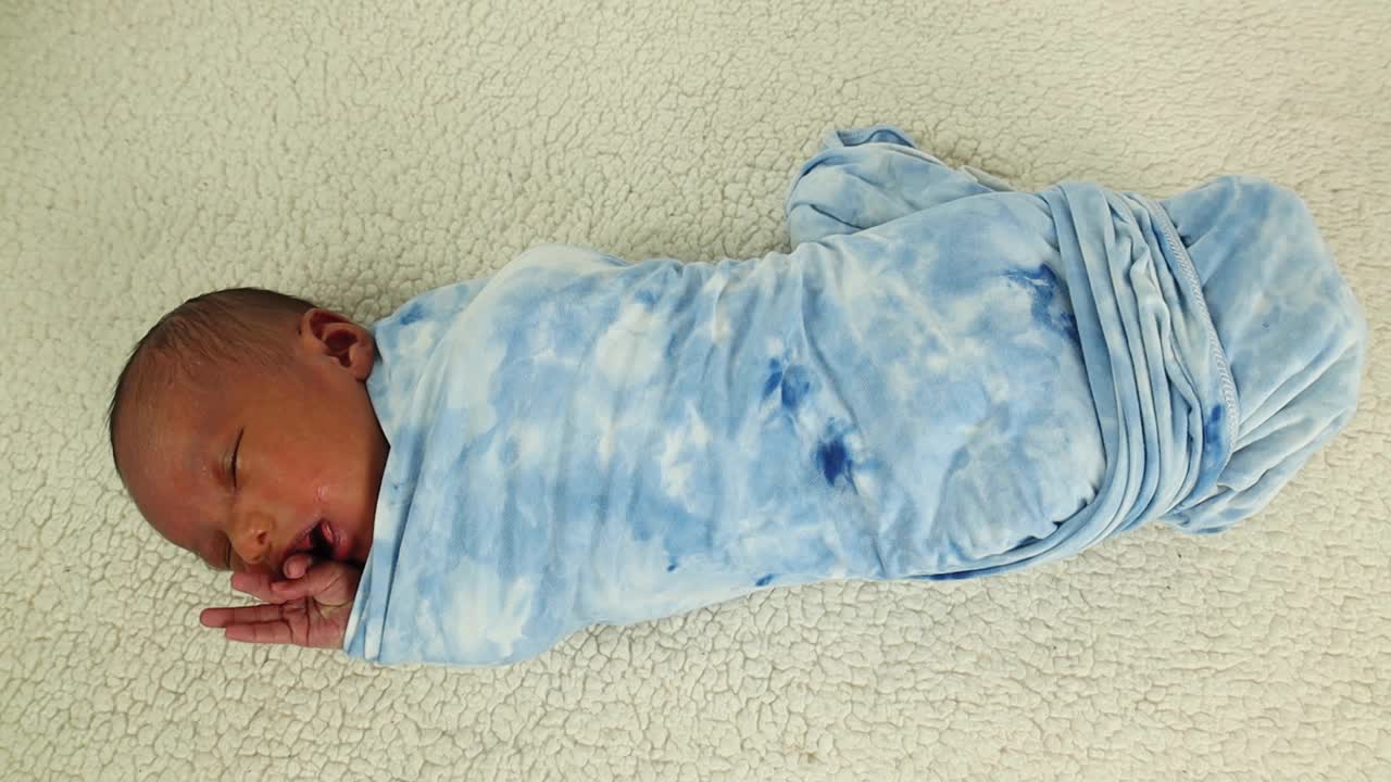 Un neonato avvolto in una morbida coperta