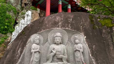 Tiro-Inclinado-Hacia-Arriba-Del-Monumento-De-La-Estatua-De-Buda-Coreano-Y-El-Templo-Saseongam-En-La-Cima-De-Una-Colina-Contra-El-Cielo-Nublado---Corea-Del-Sur,-Asia