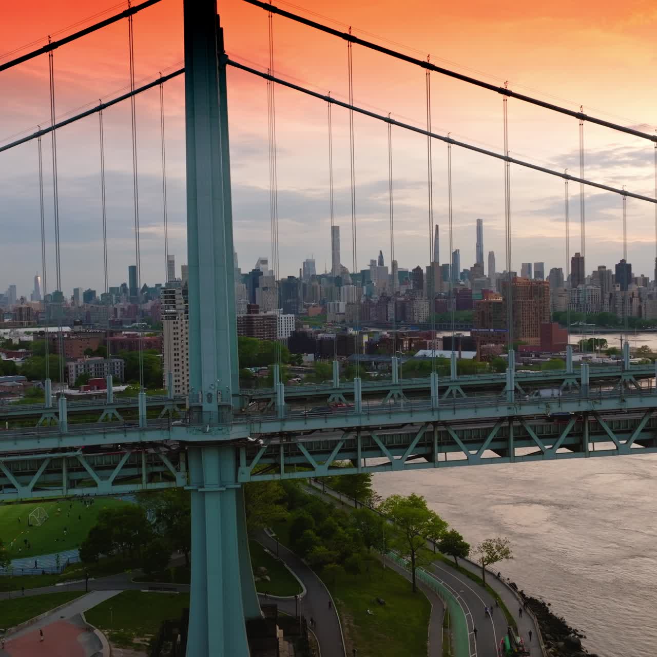 Cars driving fast by the bridge. Drone footage of Triborough Bridge against the metropolis of New York