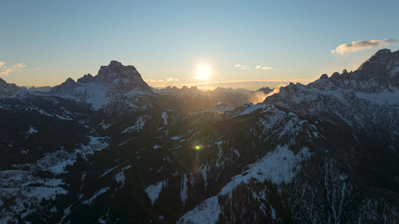 Aerial hyperlapse timelapse of Dolomites Mountains in winter season. Moving clouds and sun at sunrise