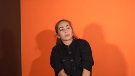 young woman posing against orange and brown backgrounds