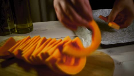 Chef-put-cut-pumpkin-on-baking-tray.-Pumpkin-dish-preparing.-Vegetable-cooking