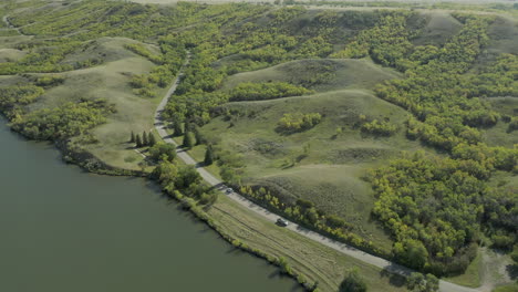 cars driving across country road in buffalo pound provincial park, saskatchewan, canada