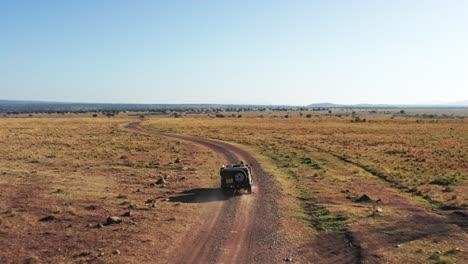 fotografía aérea de un fotógrafo de vida silvestre conduciendo un vehículo de safari en la reserva nacional de sabana de maasai mara, kenia, áfrica con hermosos paisajes, la conservación del norte de masai mara