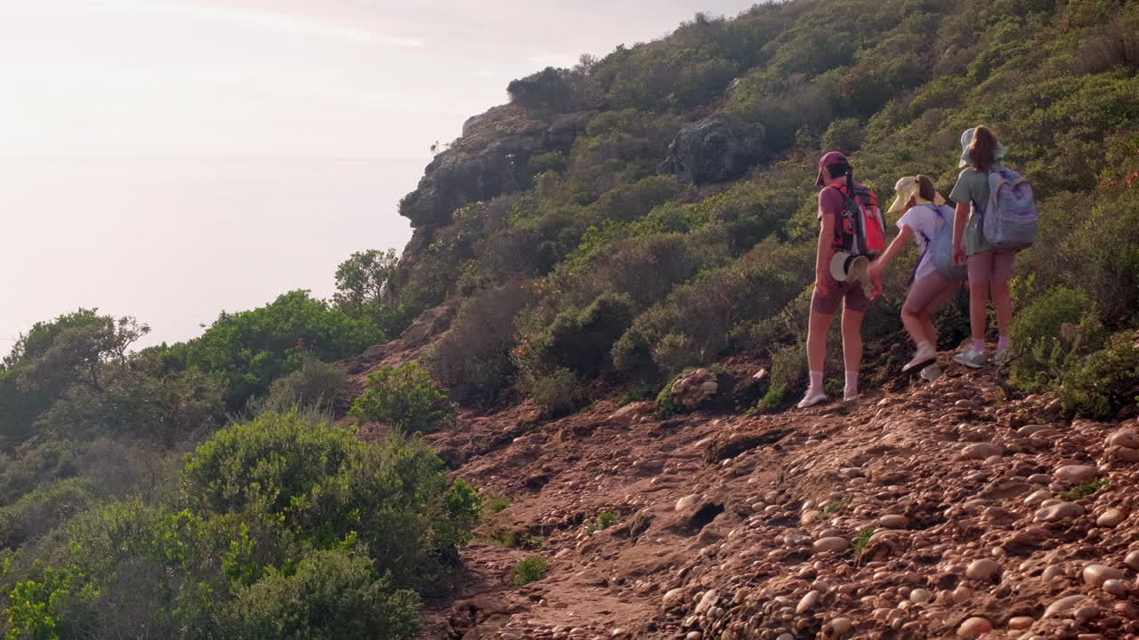Mother and twin girls hike on trail in Robberg Nature Reserve in Plettenberg Bay