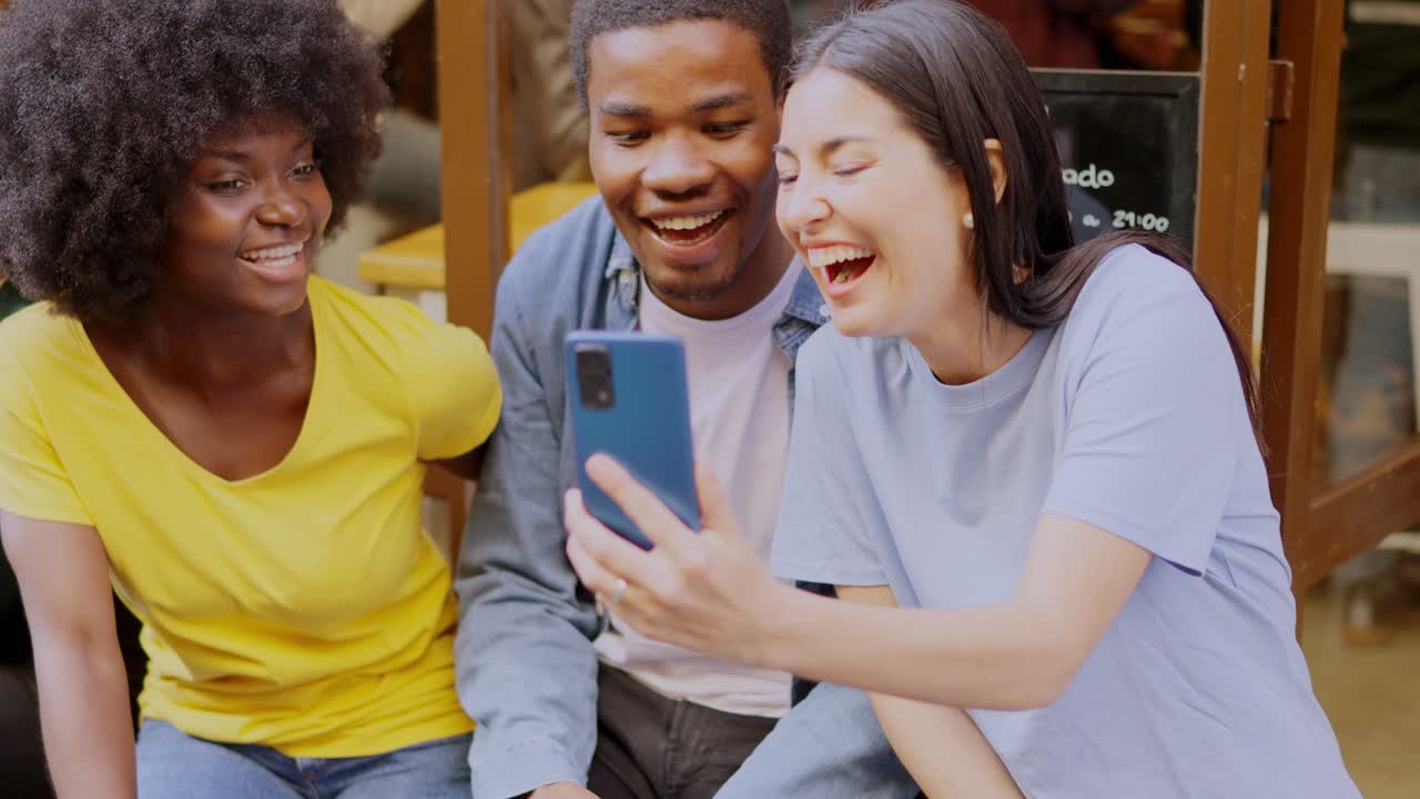 Friends laughing and sharing content on a smartphone
