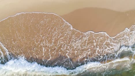 tropischer strand luftansicht, top-ansicht von wellen brechen auf tropischen weißen sandstrand. meereswellen nahtlose schleife auf dem wunderschönen sand strand.